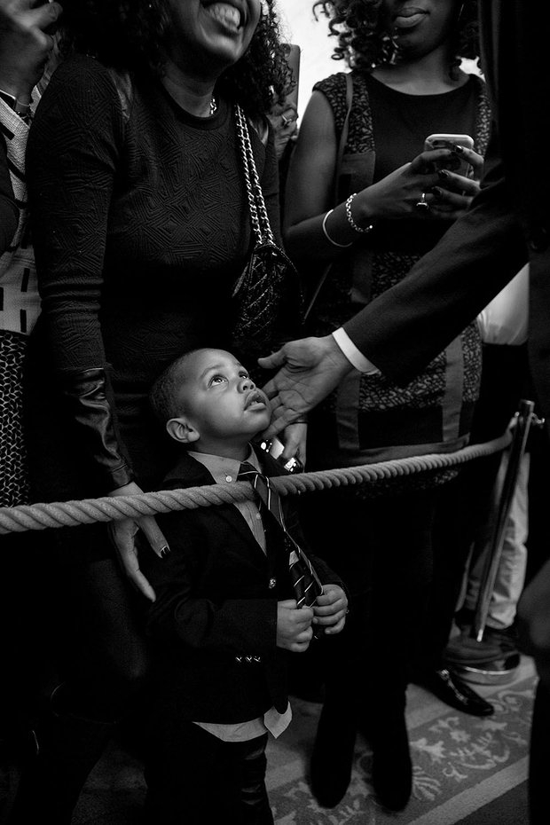 Cậu bé Clark Reynolds, 3 tuổi, không giấu nổi vẻ ngạc nhiên khi được Tổng thống Obama chạm vào má. Bức ảnh chỉ chụp bàn tay của ông Obama trên má bé Clark bởi khác với những đời tổng thống Mỹ trước, đây không phải là bàn tay của một Tổng thống người da trắng. (Ảnh: Pete Souza)